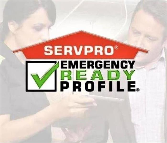 a female technician and male customer in the background with servpro logo with a green check mark in a box